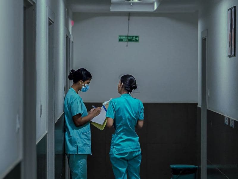 Healthcare & RCM: Nurses reviewing patient notes in a hospital corridor. Photo by Adarsh MP on Pexels.